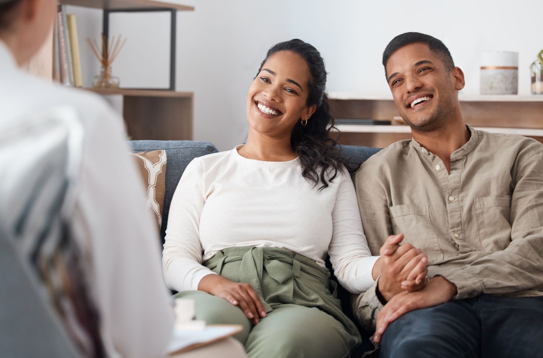 Shot of a happy young couple sitting together during a consultation with a psychologist.